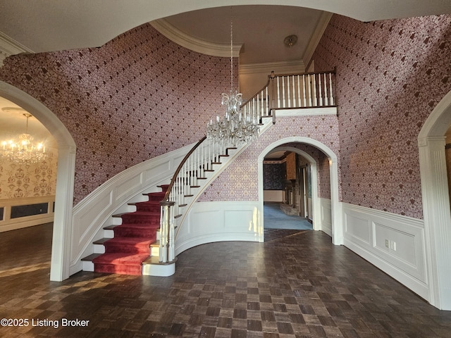 3501 Trinidad Ct, Lexington, KY 40509 - stairs featuring a chandelier, arched walkways, wallpapered walls, a wainscoted wall, and ornamental molding