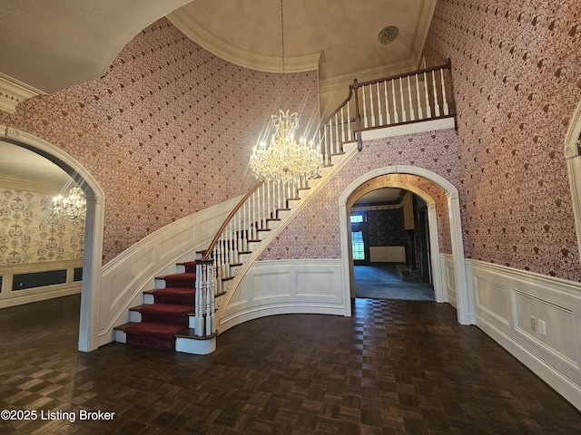 3501 Trinidad Ct, Lexington, KY 40509 - stairs featuring arched walkways, a chandelier, wallpapered walls, a wainscoted wall, and crown molding