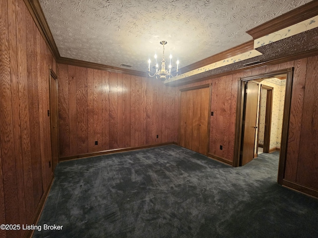 3501 Trinidad Ct, Lexington, KY 40509 - empty room featuring a chandelier, dark colored carpet, ornamental molding, wooden walls, and a textured ceiling