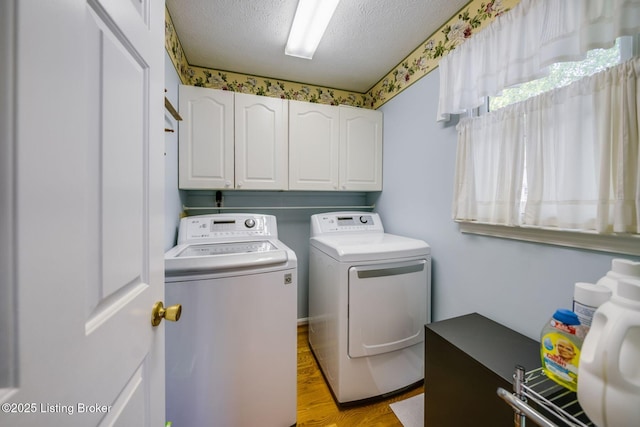 8415 Hurstbourne Woods Pl, Louisville, KY 40299 - laundry room with washing machine and clothes dryer, cabinet space, a textured ceiling, and light wood-type flooring