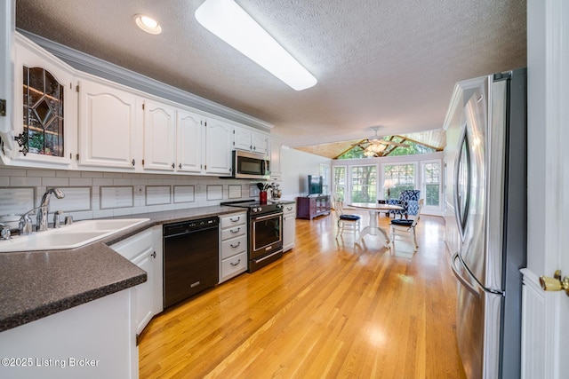 8415 Hurstbourne Woods Pl, Louisville, KY 40299 - kitchen with stainless steel appliances, dark countertops, white cabinets, light wood-style floors, and a textured ceiling