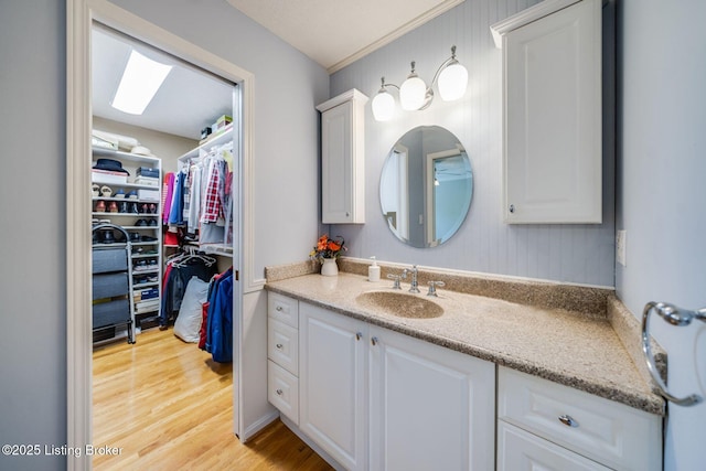 8415 Hurstbourne Woods Pl, Louisville, KY 40299 - bathroom with vanity, wood finished floors, crown molding, and a walk in closet