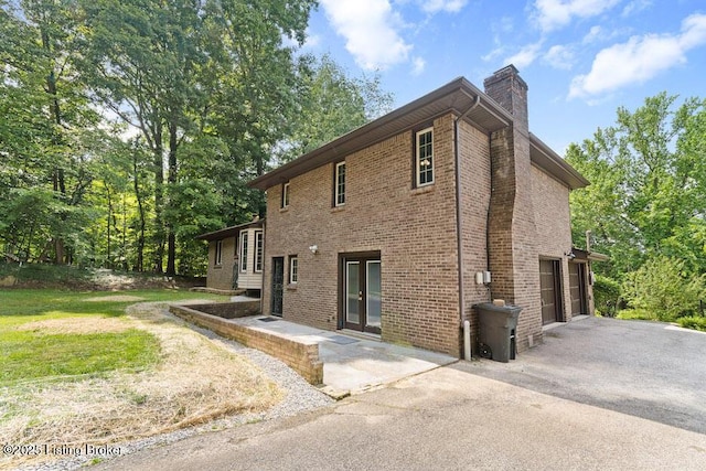 2312 Blevins Gap Rd, Louisville, KY 40272 - view of side of property with a chimney, asphalt driveway, a garage, and brick siding