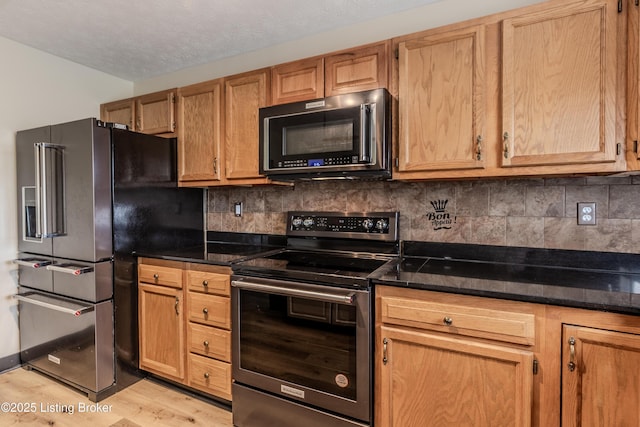 95 Sunny Meadows Dr, Vine Grove, KY 40175 - kitchen with appliances with stainless steel finishes, light wood-style flooring, decorative backsplash, and dark stone countertops