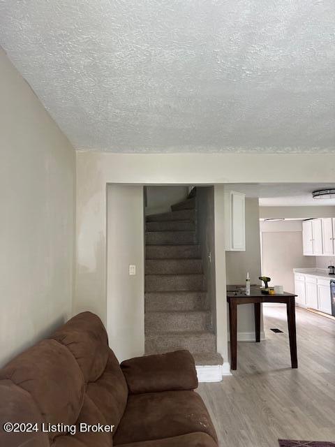 1008 Walter Ave, Louisville, KY 40215 - living area featuring a textured ceiling, light wood-style floors, and stairs
