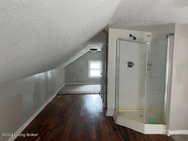 1008 Walter Ave, Louisville, KY 40215 - bathroom featuring a textured ceiling, hardwood / wood-style floors, vaulted ceiling, and a stall shower