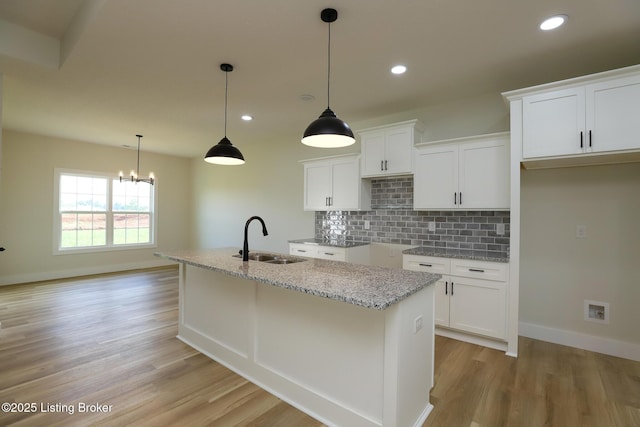 838 Otter Creek Rd, Vine Grove, KY 40175 - kitchen with white cabinets, tasteful backsplash, a kitchen island with sink, light wood-style flooring, and recessed lighting