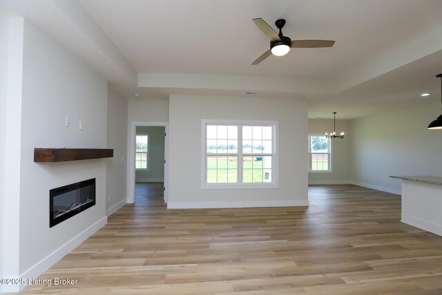 838 Otter Creek Rd, Vine Grove, KY 40175 - unfurnished living room featuring a chandelier, a glass covered fireplace, light wood-type flooring, and a ceiling fan