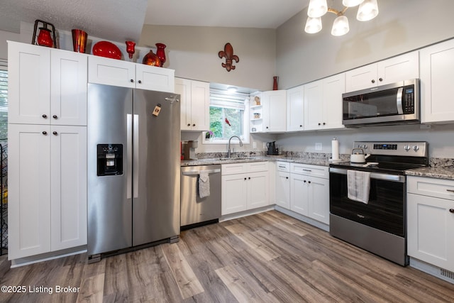 8504 Bambi Way, Louisville, KY 40214 - kitchen featuring appliances with stainless steel finishes, light wood-style floors, white cabinets, light stone counters, and open shelves