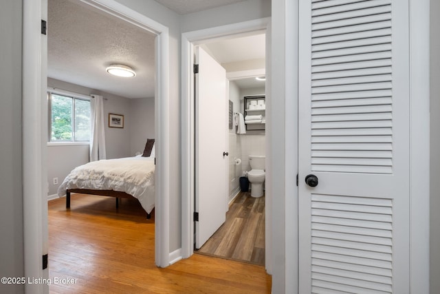 8504 Bambi Way, Louisville, KY 40214 - bedroom featuring light wood-style flooring, a textured ceiling, and connected bathroom