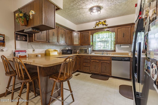 2149 Shrewsbury Rd, Leitchfield, KY 42754 - kitchen featuring dishwasher, a kitchen bar, light countertops, backsplash, and a textured ceiling