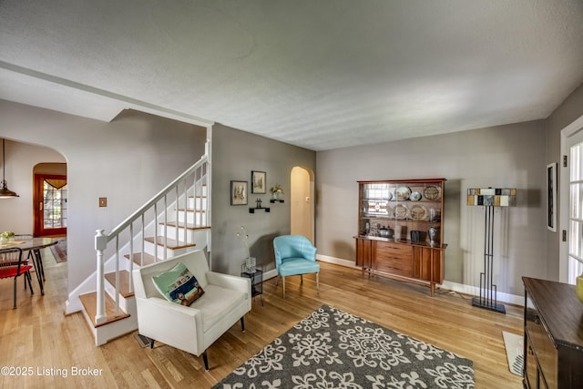 3119 Bobolink Rd, Louisville, KY 40213 - living area featuring arched walkways, light wood-style floors, and stairway