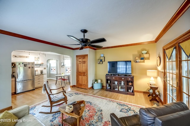 3119 Bobolink Rd, Louisville, KY 40213 - living room with arched walkways, ceiling fan, light wood-type flooring, a textured ceiling, and ornamental molding