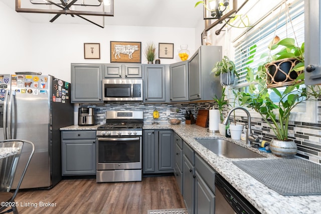 835 Forrest St, Louisville, KY 40217 - kitchen with stainless steel appliances, gray cabinetry, a chandelier, and decorative backsplash