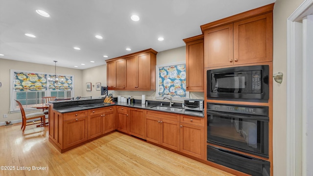 3615 Hycliffe Ave, Louisville, KY 40207 - kitchen featuring black appliances, a peninsula, a warming drawer, light wood-style flooring, and dark countertops