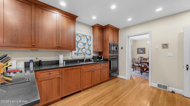 3615 Hycliffe Ave, Louisville, KY 40207 - kitchen featuring black appliances, a warming drawer, light wood finished floors, dark countertops, and recessed lighting
