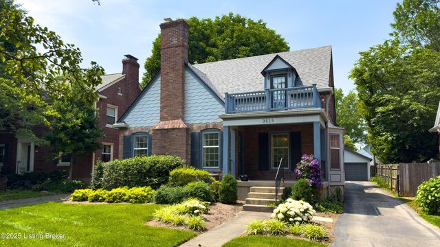 3615 Hycliffe Ave, Louisville, KY 40207 - tudor house with covered porch, a balcony, a shingled roof, brick siding, and a garage