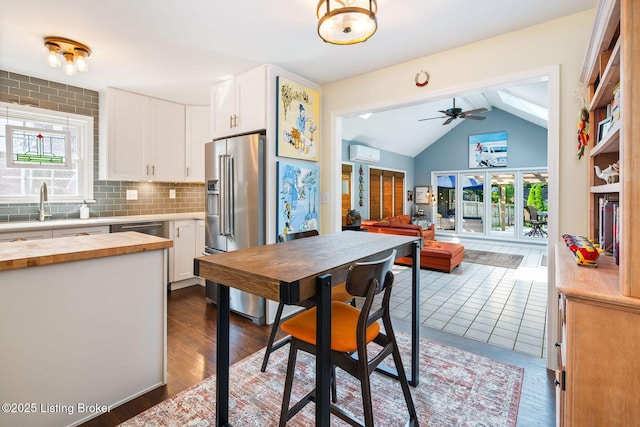 7104 Fox Harbor Rd, Prospect, KY 40059 - kitchen with butcher block counters, stainless steel appliances, a wall mounted air conditioner, lofted ceiling, and white cabinets
