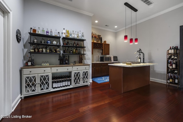 6103 Winkler Rd, Crestwood, KY 40014 - indoor bar featuring dark wood-style flooring, crown molding, stainless steel microwave, recessed lighting, and hanging light fixtures