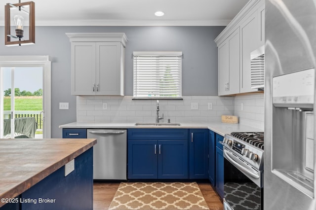 4066 Firestone Way, Shelbyville, KY 40065 - kitchen featuring appliances with stainless steel finishes, blue cabinetry, healthy amount of natural light, light countertops, and ornamental molding