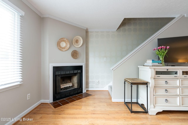 10757 Colonial Woods Ct, Louisville, KY 40023 - living room with wallpapered walls, stairs, light wood-type flooring, ornamental molding, and a fireplace with flush hearth
