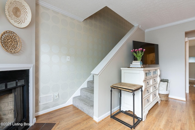 10757 Colonial Woods Ct, Louisville, KY 40023 - staircase with wood finished floors, wallpapered walls, ornamental molding, and a fireplace with flush hearth