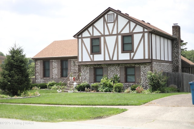 402 Bromwell Dr, Louisville, KY 40245 - tudor home with brick siding, a front yard, stucco siding, and a chimney
