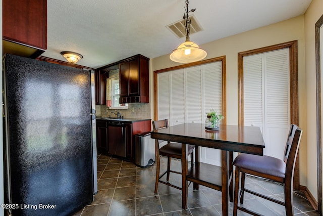 11208 Hasbrook Ct, Louisville, KY 40229 - kitchen featuring freestanding refrigerator, dishwasher, tasteful backsplash, dark tile patterned floors, and decorative light fixtures