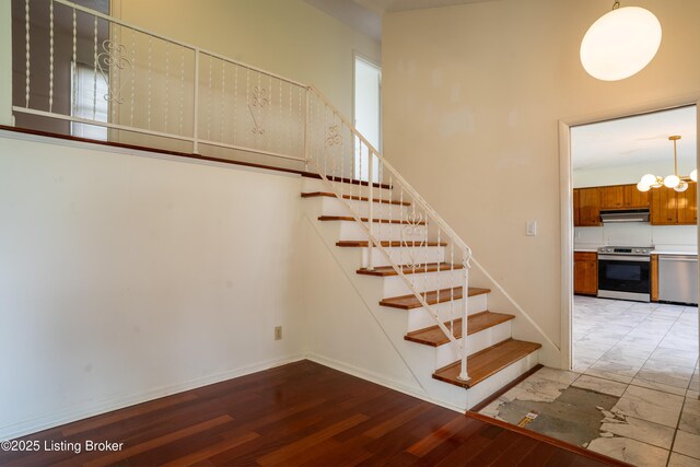 7906 Brynwood Ct, Louisville, KY 40291 - stairway with a chandelier and wood finished floors