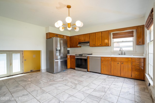 7906 Brynwood Ct, Louisville, KY 40291 - kitchen featuring stainless steel appliances, under cabinet range hood, light countertops, a chandelier, and light marble finish flooring