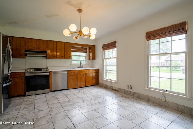 7906 Brynwood Ct, Louisville, KY 40291 - kitchen with appliances with stainless steel finishes, under cabinet range hood, light marble finish flooring, light countertops, and brown cabinets