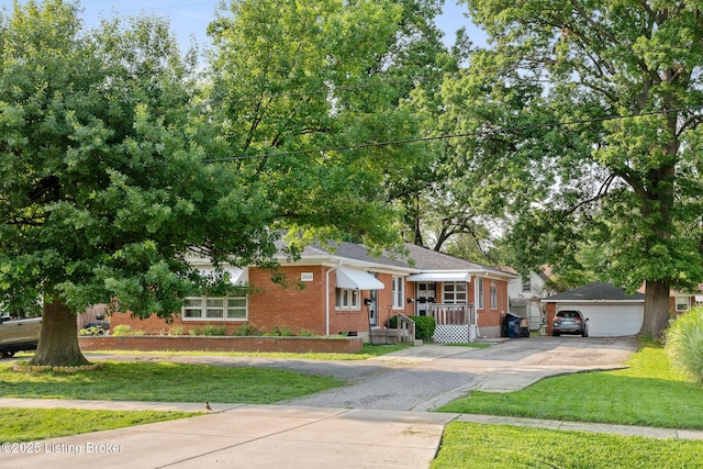 1833 Farnsley Rd, Louisville, KY 40216 - view of front of property with a front lawn, brick siding, a detached garage, an outdoor structure, and driveway