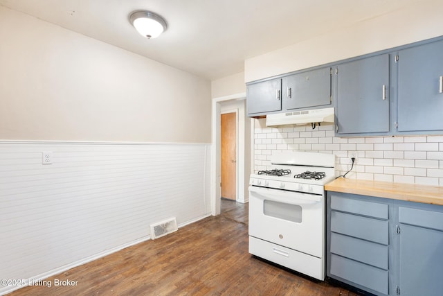 1833 Farnsley Rd, Louisville, KY 40216 - kitchen with white gas stove, under cabinet range hood, blue cabinets, a wainscoted wall, and dark wood finished floors