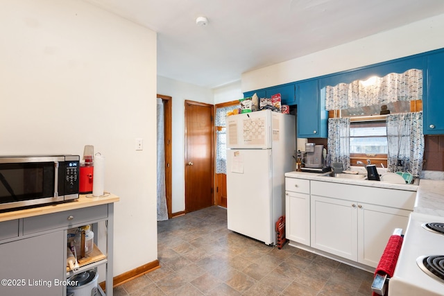 1833 Farnsley Rd, Louisville, KY 40216 - kitchen featuring stainless steel microwave, freestanding refrigerator, light countertops, stone finish floors, and stove