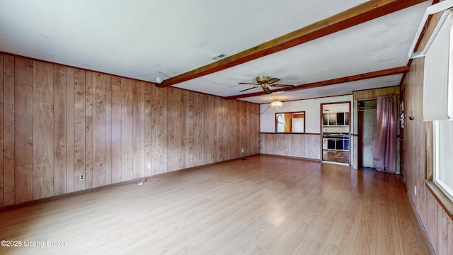 116 E Southern Heights Ave, Louisville, KY 40214 - unfurnished living room featuring wood finished floors, beamed ceiling, wood walls, and ceiling fan