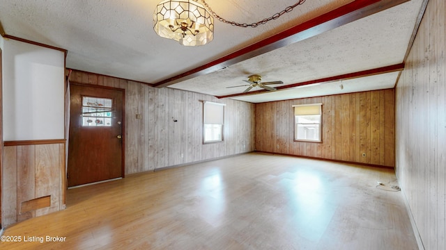 116 E Southern Heights Ave, Louisville, KY 40214 - empty room with beam ceiling, wood finished floors, a textured ceiling, wood walls, and a ceiling fan