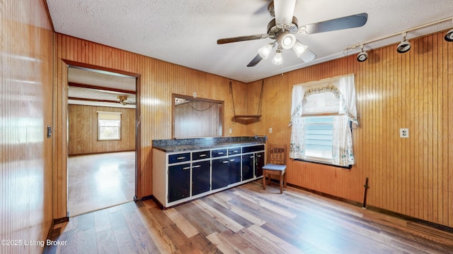 116 E Southern Heights Ave, Louisville, KY 40214 - kitchen with wood finished floors, ceiling fan, a textured ceiling, dark countertops, and wood walls