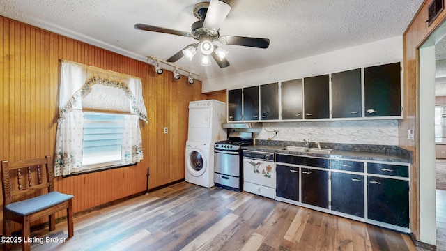 116 E Southern Heights Ave, Louisville, KY 40214 - kitchen featuring stacked washing machine and dryer, stainless steel range with gas cooktop, wood finished floors, dark countertops, and dishwashing machine