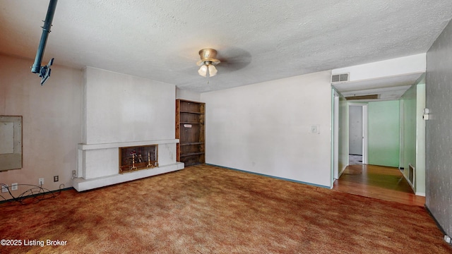 116 E Southern Heights Ave, Louisville, KY 40214 - unfurnished living room with carpet flooring, a ceiling fan, a fireplace with raised hearth, and a textured ceiling