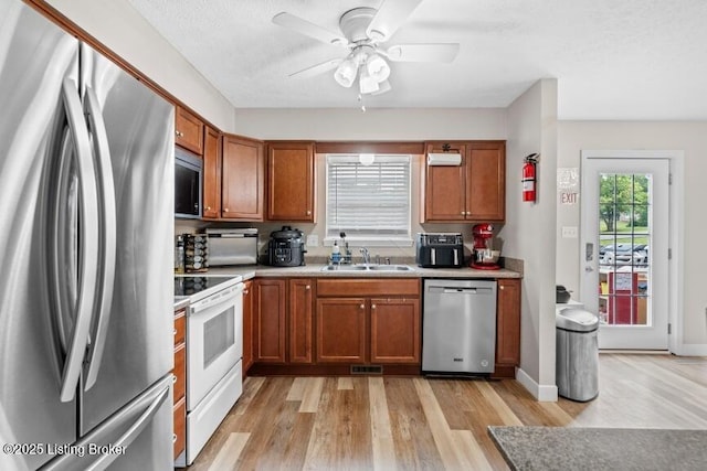 1376 Darlene Ct, Radcliff, KY 40160 - kitchen with stainless steel appliances, brown cabinets, light wood finished floors, a ceiling fan, and light countertops