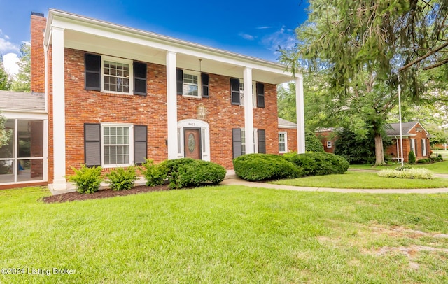 8613 Whipps Bend Rd, Bellemeade, KY 40222 - neoclassical home with a chimney, a front lawn, and brick siding