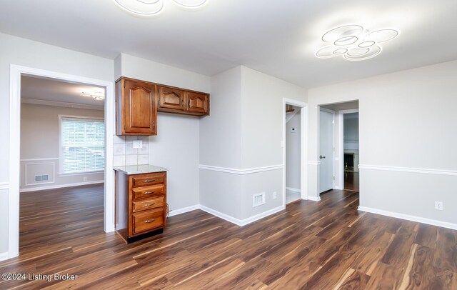8613 Whipps Bend Rd, Bellemeade, KY 40222 - kitchen with dark wood-style flooring, brown cabinets, light stone counters, and decorative backsplash