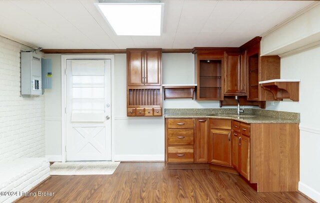 8613 Whipps Bend Rd, Bellemeade, KY 40222 - kitchen with open shelves, wood finished floors, light stone countertops, brown cabinetry, and brick wall
