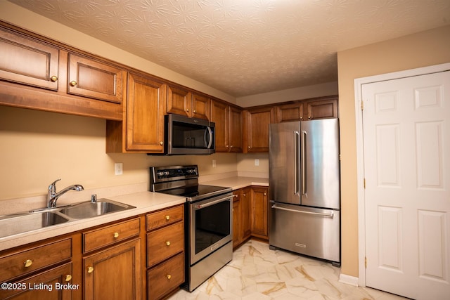 1003 Persimmon Pl, La Grange, KY 40031 - kitchen featuring appliances with stainless steel finishes, light marble finish flooring, brown cabinetry, and light countertops