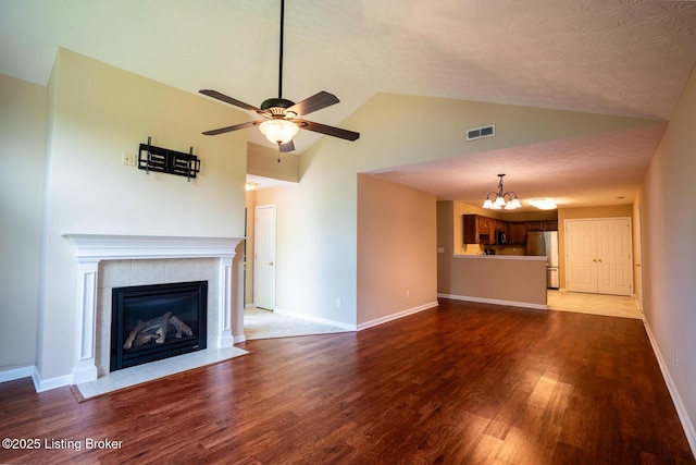 1003 Persimmon Pl, La Grange, KY 40031 - unfurnished living room featuring a chandelier, wood finished floors, a tiled fireplace, a ceiling fan, and high vaulted ceiling