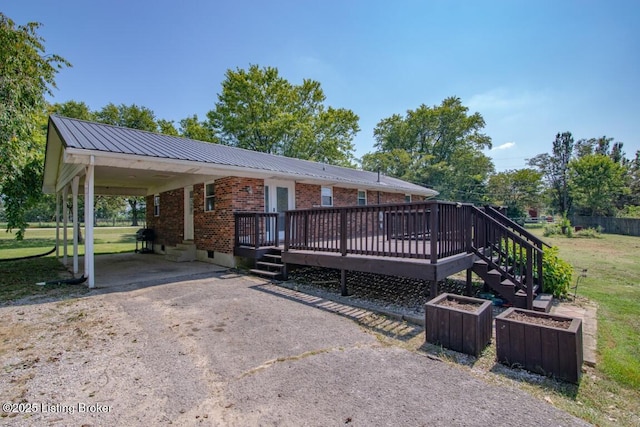 10563 S Dixie Hwy, Sonora, KY 42776 - view of front of property featuring driveway, brick siding, a wooden deck, a front lawn, and a metal roof
