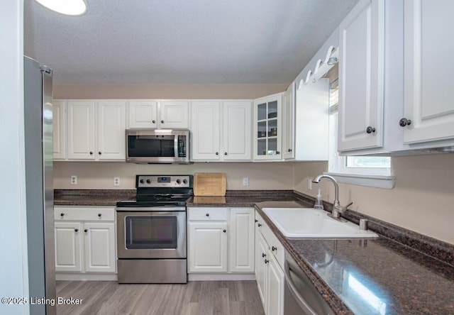 10563 S Dixie Hwy, Sonora, KY 42776 - kitchen with appliances with stainless steel finishes, white cabinets, light wood finished floors, and glass insert cabinets