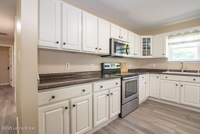 10563 S Dixie Hwy, Sonora, KY 42776 - kitchen featuring appliances with stainless steel finishes, light wood-style flooring, white cabinetry, and glass insert cabinets