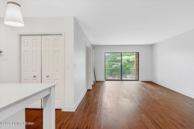5800 Coach Gate Wynde Unit 312D, Louisville, KY 40207 - unfurnished living room with baseboards and dark wood-type flooring
