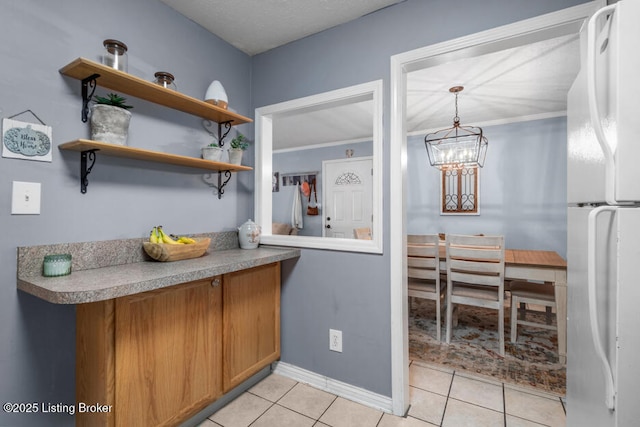 6711 Gunston Ln Unit H10, Prospect, KY 40059 - kitchen featuring freestanding refrigerator, light tile patterned flooring, brown cabinets, a chandelier, and light countertops